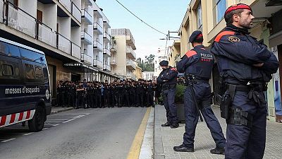 Mossos d'Esquadra permanecen dante de un grupo de policías nacionales en Pineda de Mar