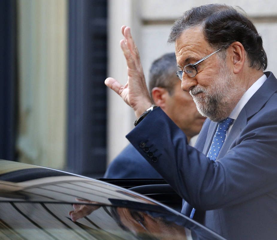 El presidente del Gobierno en funciones, Mariano Rajoy, saluda a la salida del Congreso