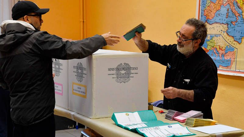 Un hombre deposita su voto en una urna instalada en un colegio electoral de Roma