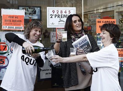 La propietaria de una administración de lotería de Pamplona descorcha una botella de champán