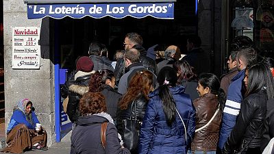 Numerosas personas hacen cola en Madrid para adquirir décimos de lotería del próximo Sorteo de Navidad