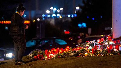 Una mujer reza en Bruselas delante de una ofrenda floral a las víctimas Una mujer reza en Bruselas delante de una ofrenda floral a las víctimas
