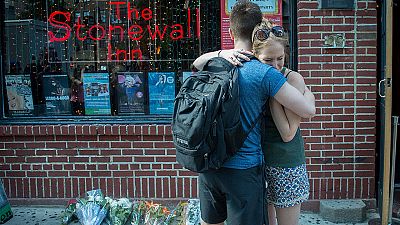 Una pareja se abraza frente a uno de lugares de vigilia por las víctimas del atentado en Orlando.