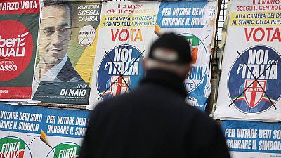 Un hombre mira carteles electorales en Pomigliano D'Arco, cerca de Nápoles (Italia)