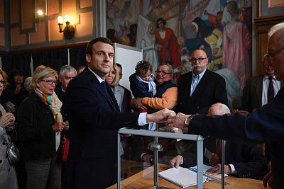 El candidato presidencial Emmanuel Macron (C) vota en Le Touquet, al norte de Francia