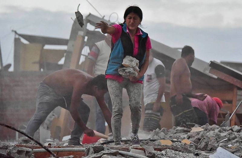 Una vecina de la localidad ecuatoriana de Tarqui retira escombros a mano 