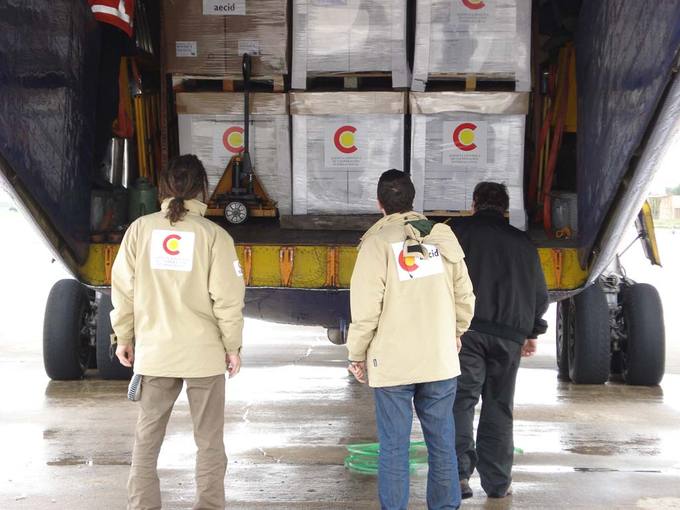 Varios trabajadores cargan las cajas con ayuda humanitaria en el avi&oacute;n con destino a Birmania