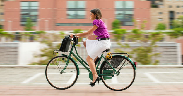 Una mujer conduce su bicicleta eléctrica Una mujer conduce su bicicleta eléctrica
