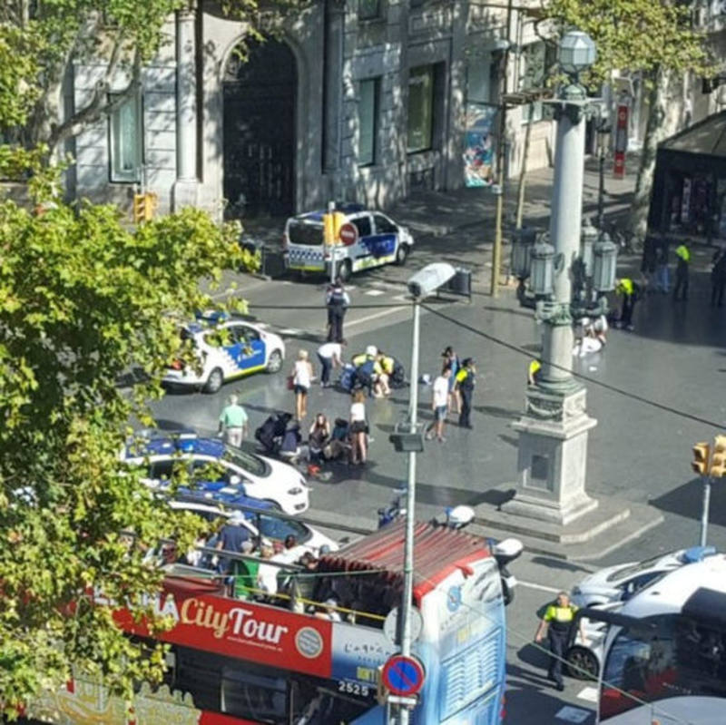 Policías y servicios medicos atienden a las víctimas del atentado este jueves en Barcelona