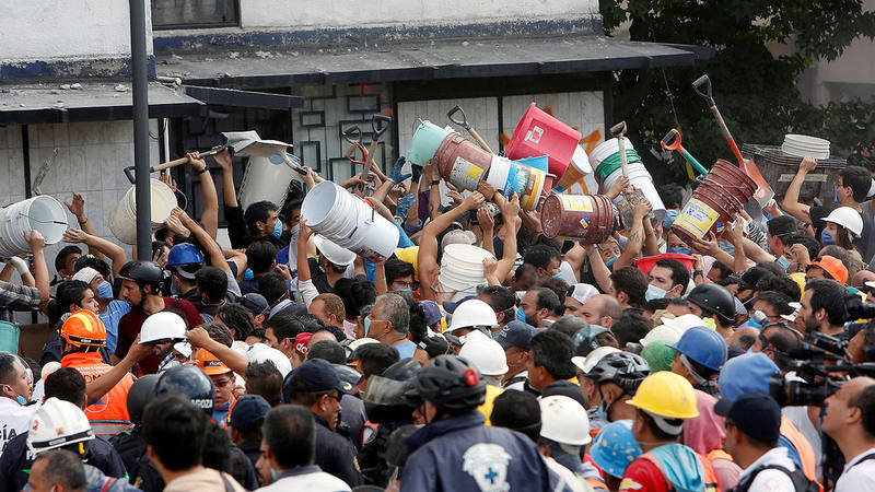 Voluntarios se pasan cubos y palas para ayudar en las labores de rescate tras el terremoto en Ciudad de México