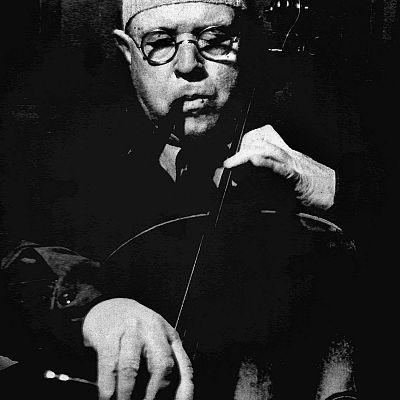 Hombre con gafas tocando un violonchelo en una foto en blanco y negro de baja iluminación.  Acompaña a un programa de radio titulado \"Querido maestro...\"