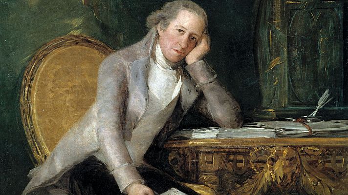 Retrato de Jovellanos pensativo, sentado en silla dorada con un papel en la mano. Lleva chaqueta clara y camisa blanca, ante un escritorio con plumas y papeles.