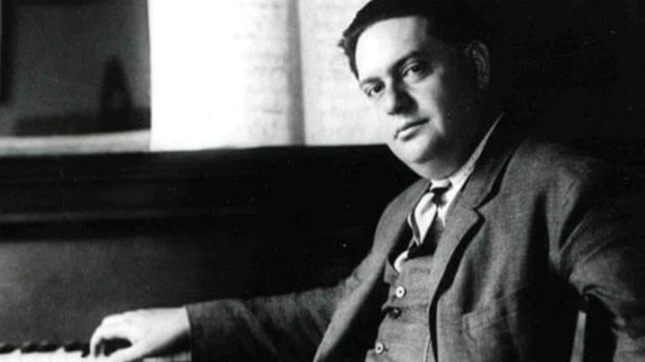 Retrato clásico en blanco y negro de un hombre en traje y corbata sentado al piano, con una mano sobre las teclas.