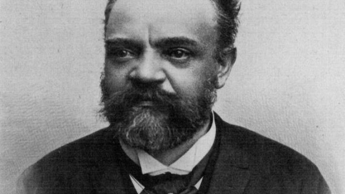 Retrato antiguo en blanco y negro de un hombre con barba y bigote, vestido formalmente. La imagen pertenece a un programa o relato llamado \"Sinfonía de la mañana\".