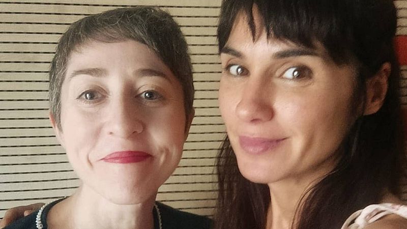 Primer plano de Elena Medel y Nuria Labari, escritoras españolas, sonriendo. Elena con pelo corto grisáceo, Nuria con pelo largo oscuro.