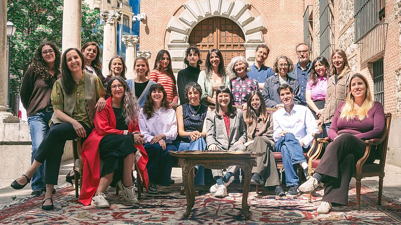 Retrato grupal de unas 23 personas, mayormente mujeres, en un patio con arquitectura hist�rica, posando sobre una alfombra persa. Todos miran a la c�mara sonriendo.