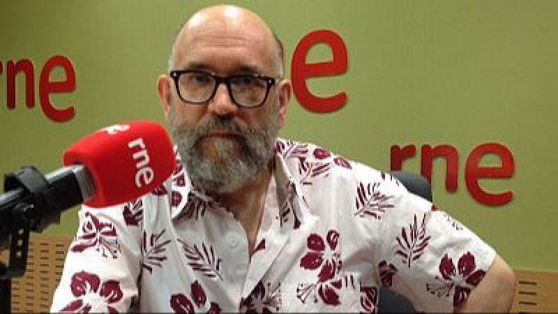 Marcos Ordóñez, escritor y docente, posa en un estudio de radio con un micrófono RNE y el logo de la emisora al fondo.
