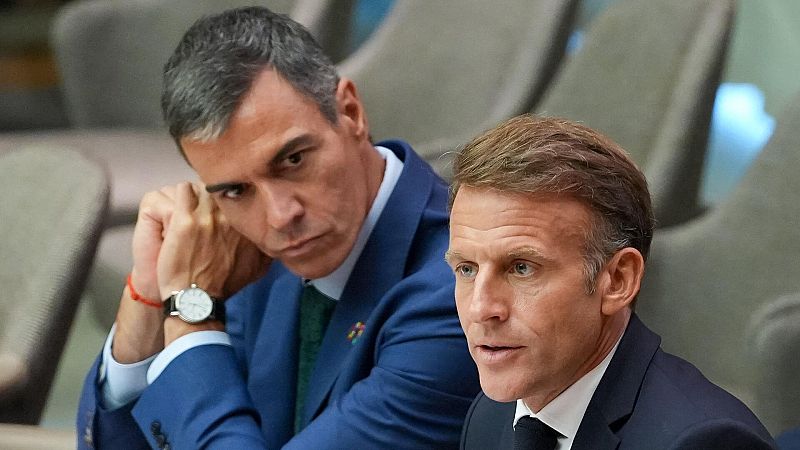 El presidente francés, Emmanuel Macron, interviene mientras el presidente español, Pedro Sánchez, le observa en un segundo plano