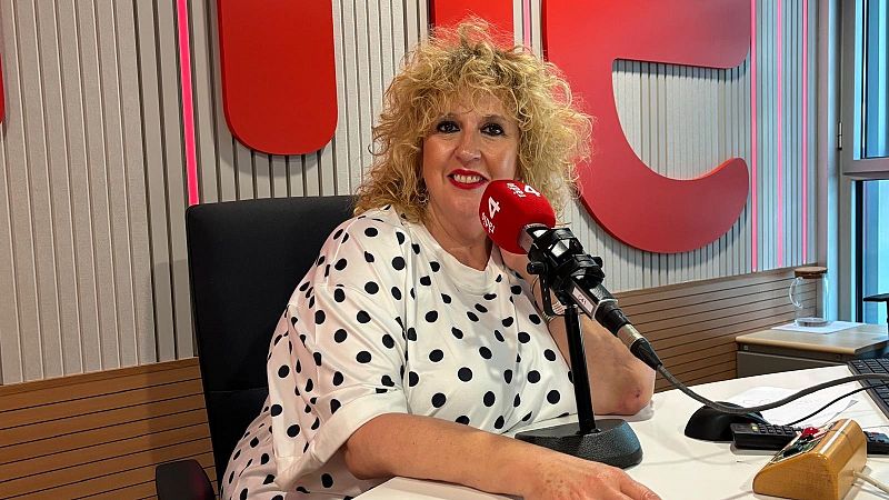 Silvia Tarragona en estudio de R�dio 4, con micr�fono rojo y fondo de paneles luminosos y formas rojas.