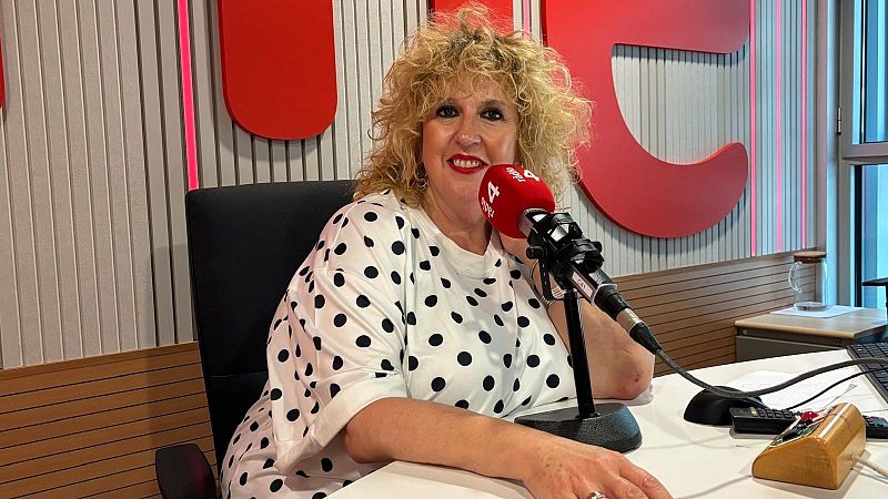 Silvia Tarragona, presentadora de radio, sonr�e en un estudio con micr�fono rojo "4 dies", escritorio con equipo y teclado, vestida con camiseta de lunares.