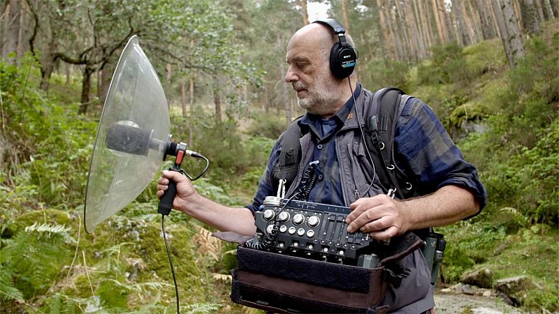 Carlos de Hita, con auriculares SONY y equipo de grabaci�n, captura sonidos en un bosque frondoso.