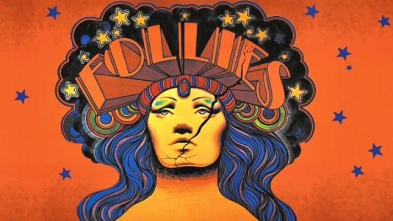 Busto de mujer con tocado "FOLLIES", rostro agrietado, cabello azul y morado, sobre fondo naranja con estrellas.