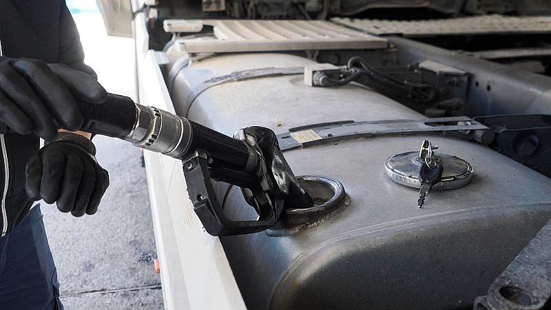 Mano enguantada repostando combustible en un vehículo pesado. Se observan llaves sobre el depósito.