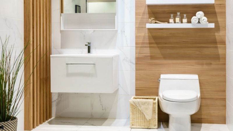 Ba�o moderno con lavabo blanco, inodoro y detalles de madera.  Texto en la pared: "La Matinera - Charas Vega", indicando un test de personalidad.