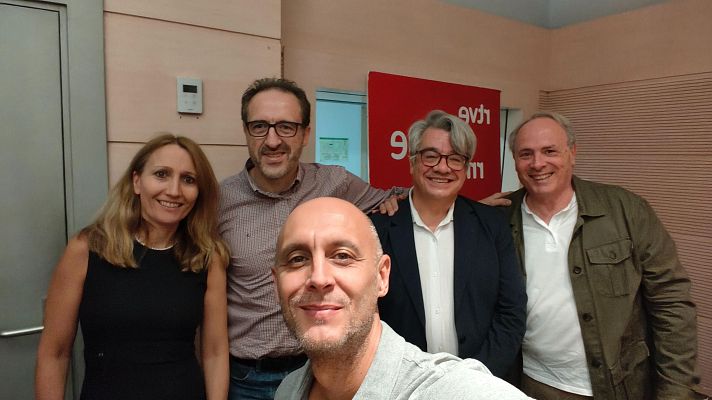 Paco Asensi se toma un selfi sonriente junto a cuatro acompañantes en un estudio de Radio Nacional de España (RNE), con el logotipo de la emisora visible al fondo.