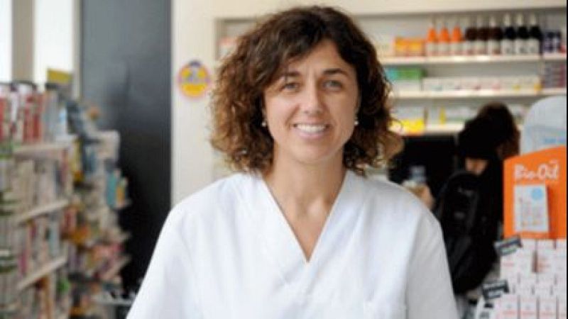 Emi Salles, vestida con bata blanca, sonr�e en una farmacia rodeada de estanter�as con productos y un expositor naranja de la marca "Bio-Oil".