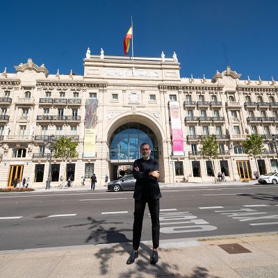 El arquitecto David Chipperfield posa frente a la sede del Banco Santander en Santander, con las palabras \"BUS\", \"TAXI\" y \"MOTO\" pintadas en el asfalto ante él.