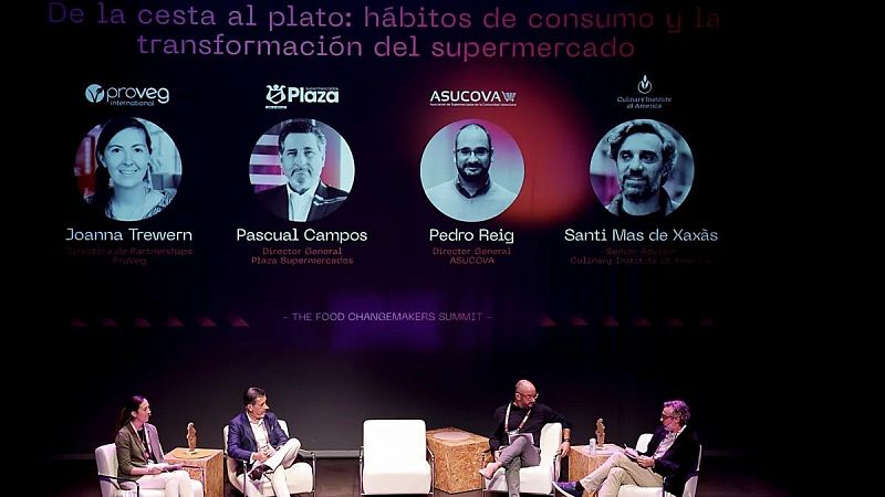 Mesa redonda en 'The Food Changemakers Summit' con Joanna Trewern, Pascual Campos, Pedro Reig y Santi Mas de Xaxàs debatiendo bajo una gran pantalla informativa.