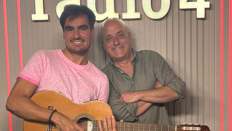 Pau Pin�s, con una guitarra, y Goyo Prados posan sonrientes en el estudio de R�dio 4, decorado con paneles ac�sticos y luces LED rojas.
