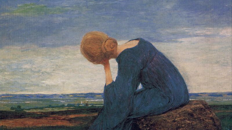 Mujer sentada de perfil sobre una roca, con un vestido azul, contempla una llanura extensa bajo un cielo nublado.