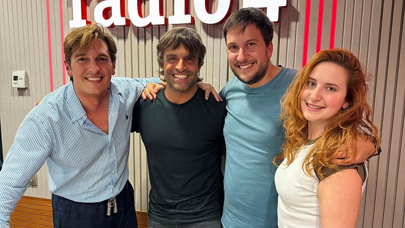 Cuatro personas posan abrazadas y sonrientes frente a una pared con paneles ac�sticos y el r�tulo de una emisora.