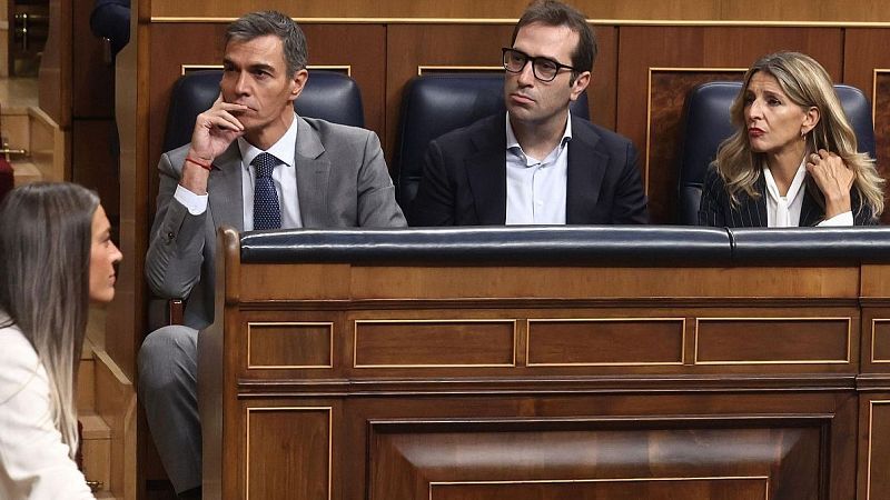 Tres miembros del Gobierno, incluyendo a Pedro S�nchez y Yolanda D�az, asisten concentrados a una sesi�n parlamentaria en el hemiciclo.