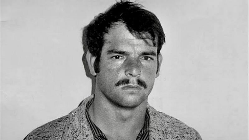 Retrato policial en blanco y negro de un hombre de cabello oscuro, patillas anchas y bigote tupido, mirando de frente con expresi�n seria.