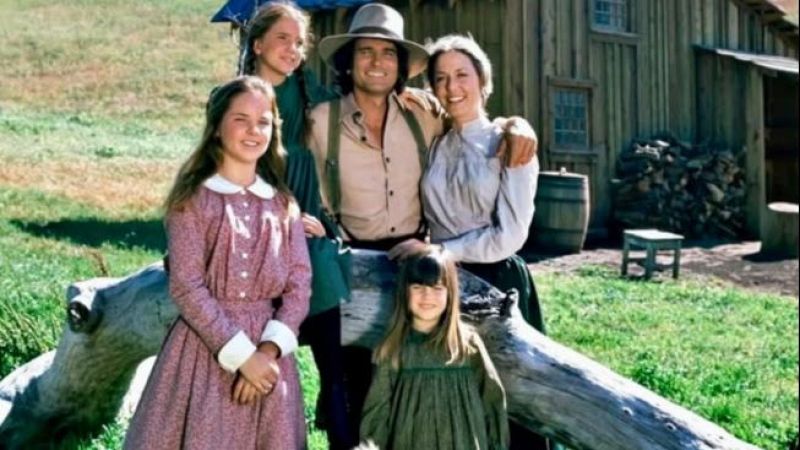Fotograf�a promocional de la familia Ingalls posando alegremente en un entorno rural junto a su caba�a.