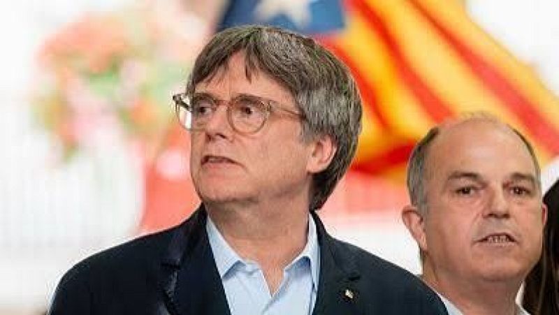 Carles Puigdemont y Jordi Turull participan en un acto p�blico junto a una bandera estelada catalana.