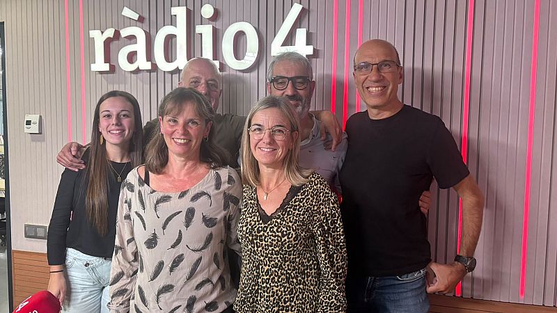 Seis personas posan sonrientes en un estudio de radio con paneles de madera y luces rojas, bajo el r�tulo de R�dio 4.