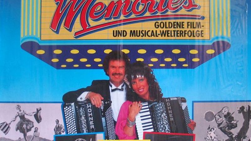 Portada de disco con la palabra �Memories� y el d�o musical tocando acordeones frente a un fondo azul claro.
