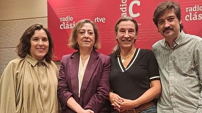 Cuatro personas posan sonrientes ante un panel rojo con logotipos de radio y televisi�n.