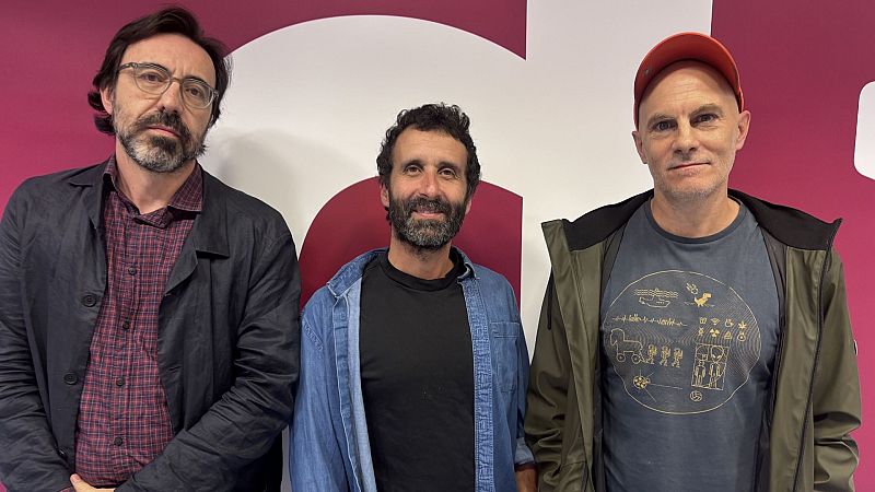 Plano medio de tres hombres posando en un estudio de radio, incluyendo a Israel Elejalde, Emilio Tomé y Pablo Remón ante un fondo corporativo de líneas curvas.