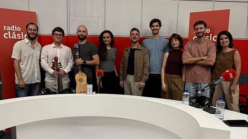 Nueve personas posan en un estudio de radio tras una mesa blanca con micr�fonos, botellas de agua y auriculares.