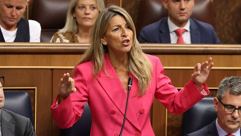 Yolanda Díaz gesticula frente al micrófono en el Congreso de los Diputados luciendo una chaqueta fucsia.