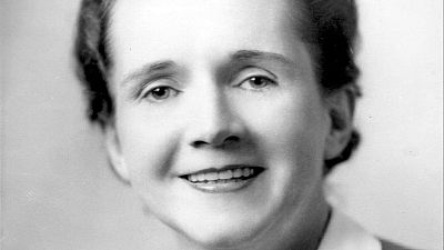Primer plano en blanco y negro de la cient�fica Rachel Carson sonriendo a la c�mara con una expresi�n serena y el cabello oscuro recogido.
