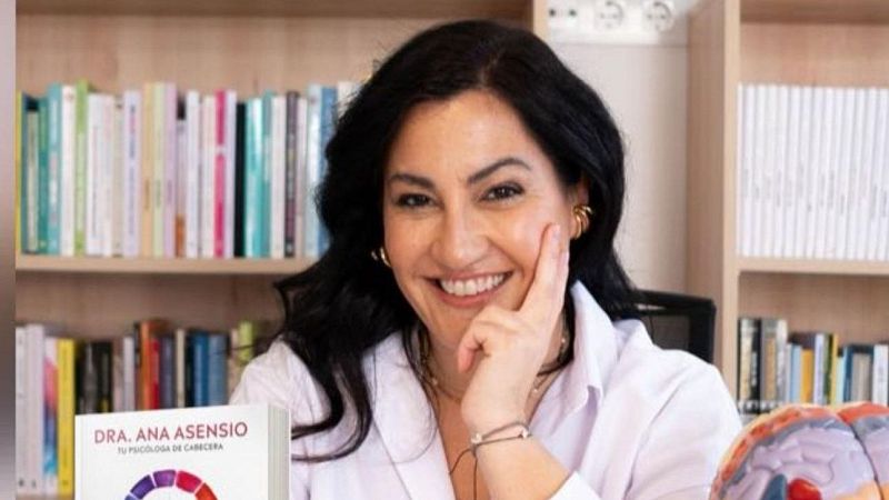 La psic�loga y escritora Ana Asensio sonr�e en su despacho junto a su libro y una maqueta de cerebro.