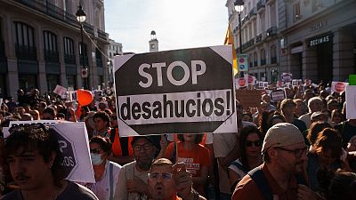 Manifestaci�n por el derecho a la vivienda en Madrid con pancarta �STOP desahucios!� y asistentes con camisetas naranjas.