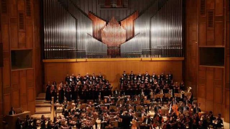 Concierto sinf�nico-coral en un auditorio cl�sico con orquesta, coro y un gran �rgano tubular de fondo.