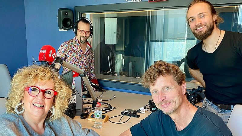 Cuatro personas posan sonrientes en un estudio de radio rodeadas de micr�fonos y equipamiento t�cnico profesional.